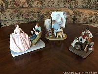 Three Norman Rockwell figurines displayed on a table showing front-side angle.