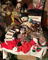 Photo capturing full assortment of vintage Christmas decorations including plush toys, crocheted items, lights, candy canes, and small figures on a table.