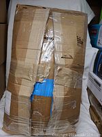 Box packaging of the pet bed, showing significant tape and wear from shipping or storage.