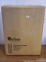 Photo showing sealed cardboard box of Furinno storage tower, model and details visible on box front.