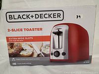 Photo of the Black+Decker 2-Slice Toaster box showing brand, model, and key features like extra-wide slots and high lift lever.