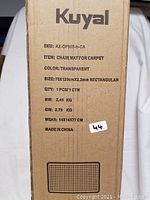 Photo of original Kuyal chair mat packaging box showing product details like SKU, dimensions, material, and origin