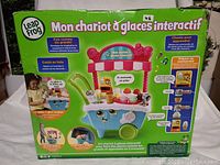 Box packaging of LeapFrog Scoop & Learn Ice Cream Cart featuring French text and images of the interactive ice cream cart toy with play features shown.