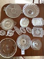 Overview of all serveware on wood table showing platters, bowls, cups, saucers and dishes