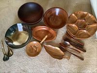 Lot display showing silver plated silverware with wood bowls and nut/candy dishes on Lazy Susan base.