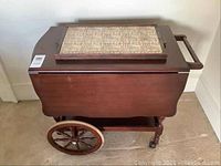 Full view of wood tea cart with closed extension leaves and tile tray on top.