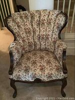 Front three-quarter view of armchair showing overall shape, upholstery pattern and wood frame