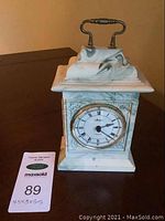 Front view of Aynsley Portlandware Georgian marble-effect mantle clock showing clock face and metal handle.