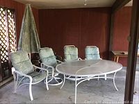 Full set on covered porch: table, six chairs, umbrella