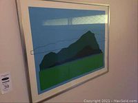 Framed print showing abstract mountain landscape in blue and green with silver frame