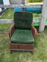 Front view of the Art Deco club chair showing green velvet upholstery and cane and rattan frame.