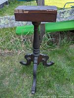 Photo of the Victorian walnut table base outdoors, showing overall front view with worn top platform and decorative legs.