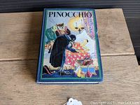Front cover of the 1932 Pinocchio book showing colorful period illustration and title.