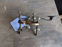 Side angle showing the brass and metal telegraph tapper with mounting screws and black knob