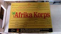 Photo of the top of the game box showing the Afrika Korps title, vintage styling, and military unit graphics.