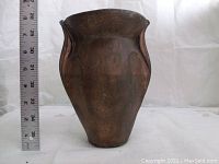 Brass vase side view showing height with ruler approximately 8 inches tall