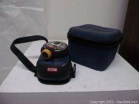 Ryobi manual laser level with strap and zippered case displayed on white surface.