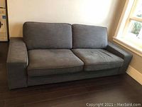 Large steel grey/blue cloth sofa with removable cushions, shown from front angle.