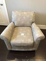 Front view of the patterned fabric easy chair showing seat cushion and armrests.