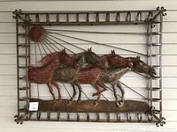Front-facing view of the Mexican metal wall sculpture showing four horses in motion with a sun and grid frame design.