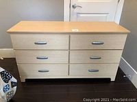 Front view of solid laminate 6 drawer chest of drawers showing six metal handled drawers and light wood finish