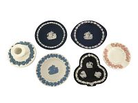 Overview of the six-piece Wedgwood set showing the candle holder, ashtray, and four Jasperware plates with classical motifs and borders of contrasting color.
