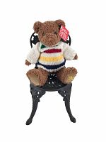 Full view of the Gund Hudson's Bay teddy bear seated on the black cast iron chair