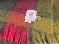 Close-up of the mohair throw labels showing brand and material composition.