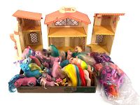 Photo of foldable Lullaby Nursery House with open sections and a large quantity of My Little Pony figures displayed in front in a box.