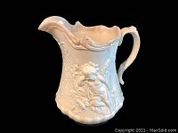 Front-side view of vintage ceramic pitcher with embossed Cupid design on white surface