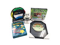 Full view of all items included in toy lot with Baby Yoda glass frame, Perfection game, Simon Air game, Rick and Morty construction set, and LEGO Stormtrooper clock.