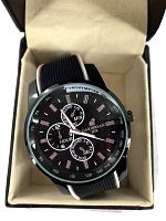 Front view of the Caribbean Joe men's wristwatch showing the black dial, tachymeter bezel, and vinyl strap inside the original case.