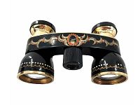 Front view of vintage black opera glasses showing decorative painted design and rhinestone on bridge, gold accents, adjustable lenses.