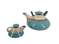Photo showing two glazed pottery teapots with beige dripping glaze over turquoise blue, one larger and one smaller, view from side and slightly angled