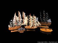 Photo showing all six models together: Mayflower, HMS Victory, Cutty Sark, largest unnamed ship, smallest unnamed ship, and a wooden row boat.