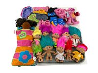 Photo of 10 Troll dolls with colorful hair and 1 Groovy Girl doll in a striped sleeping bag, additionally showing extra outfits.