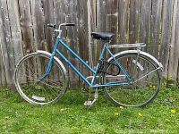 Full side view of the vintage ladies bicycle with light blue frame, black saddle, and chrome rear rack.