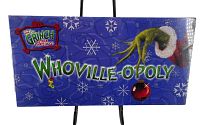 Photo of the front side of the Whoville-Opoly board game box showing branding and graphics with the Grinch's hand and Christmas ornament.