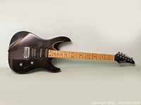 Full view of the black Samick electric guitar showing the body, fretboard, and headstock.