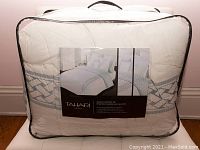 Photo of packaged Tahari Home queen size comforter set showing folded comforter and label with brand and style.