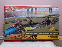 Box showing full racecar set with two cars, controllers, and over 32 feet of track including loop and ramps