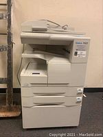 Front and right side view of the Konica 7022 copier showing paper trays and top document feeder.