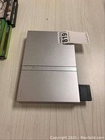 Sony PlayStation 2 slim console top view showing silver case and front-loading disc tray