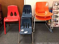 Photo showing five children's chairs: two blue chairs with metal legs, one red chair with four legs, two orange chairs with metal sled legs.