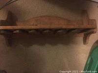 Top view of rustic wooden wine glass holder showing shelf and wine glass hangers underneath.