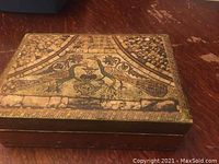 Closed view of gold-tone decorative jewelry box with bird motif