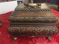 Front angled view showing decorative carvings and brass handle