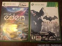 Two Xbox 360 game cases: Child of Eden and Batman Arkham City, shown side by side, both with full cover art and case intact.