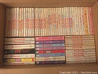 Photo showing 48 paperback books mostly from the Sweet Valley High series, arranged spine-up in a box, showing the series title and author Francine Pascal.