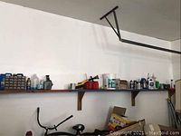 Wall shelves holding multiple gas cans and various chemical bottles and containers
